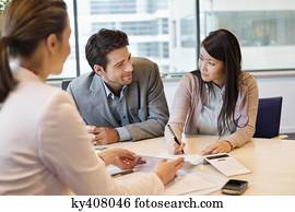 Couple signing documents with real estate agent