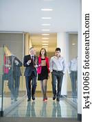 Business executives discussing in an office corridor Business executives discussing in an office corridor