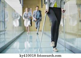 Disabled woman walking with a man and a woman running behind her Disabled woman walking with a man and a woman running behind her