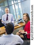 Business executives discussing in an office Business executives discussing in an office