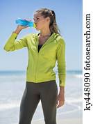 Woman drinking water on the beach