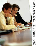 Businessman and businesswoman sitting at table