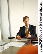 Businessman sitting at table talking.
