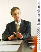 Businessman sitting at table talking.