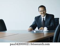 Mature businessman sitting at conference table