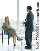 Businessman speaking to woman sitting in lobby