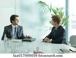 Two businessmen sitting at table, having meeting