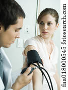 Doctor taking woman's blood pressure