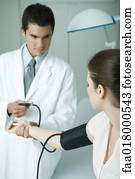 Doctor taking woman's blood pressure