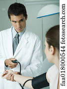 Doctor taking woman's blood pressure