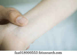 Doctor taking woman's pulse, close-up