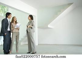 Female real estate agent showing house to young couple