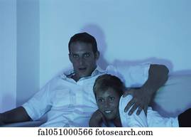 Couple watching TV together at night