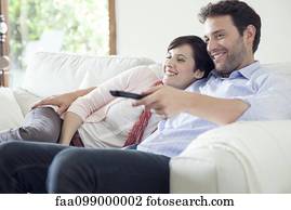 Couple watching TV together on sofa