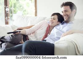Couple watching TV together on sofa