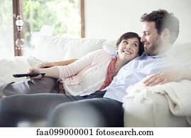 Couple watching TV together on sofa
