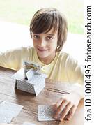 Boy building house of cards