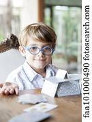 Little boy building house of cards