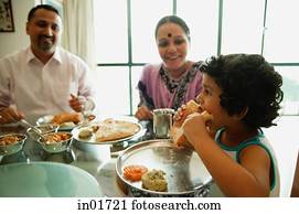 Family of three sitting down to a meal Family of three sitting down to a meal