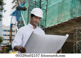Man with helmet, looking at plans Man with helmet, looking at plans
