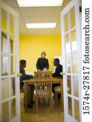 Businessmen in full suit conversing in an office