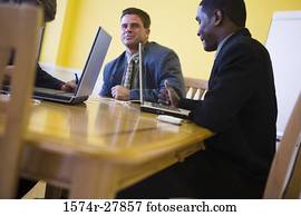 Businessmen in full suit conversing in an office