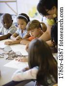 Boy and girls  paying attention to teacher in an art class