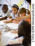 Boy and girls paying attention to teacher in an art class