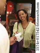 Young woman handing a credit card to a sales clerk in a store