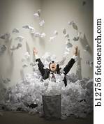 Businessman buried in mountain of crumpled papers