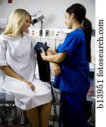 Female patient with blood pressure cuff during examination with nurse