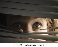 A woman peeping through venetian blinds Stock Photography | is526-025 ...