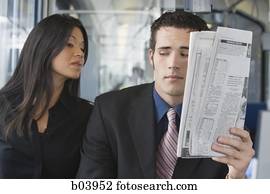 Woman looking over man's shoulder on bus or subway