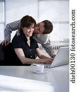 Woman on a laptop getting a kiss