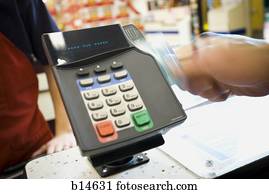 Person swiping debit card at POS machine