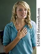 Young woman with hand over heart.