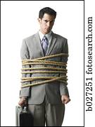 businessman in a full suit tied up with a rope around his mid section