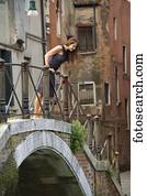 Italy, Venice, Mature woman looking over railing while standing on bridge