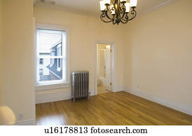 Empty room in apartment with hardwood floor and heater