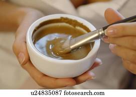 Woman compounding healing earth for a facial mask