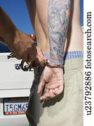 oficial, handcuffing, tatuado, homem jovem