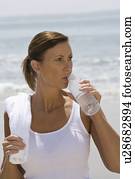 Woman drinking water at the beach