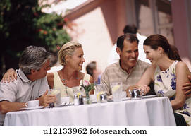 Two couples having dinner on the patio of a restaurant