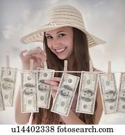 Woman hanging 100 dollar bills on clothesline