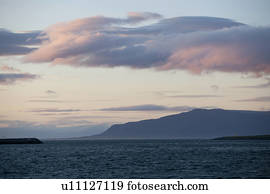 Family group climbing a rocky rough incline, in silhouette