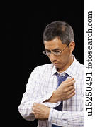 Studio shot of man buttoning cuff