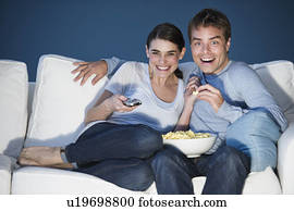 couple watching tv on sofa and eating popcorn