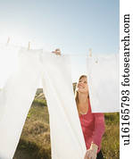 Woman hanging laundry on clothesline 