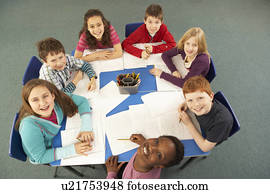 Overhead View Of Schoolchildren Working Together At Desk
