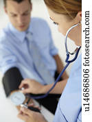 Doctor taking young man's blood pressure Doctor taking young man's blood pressure